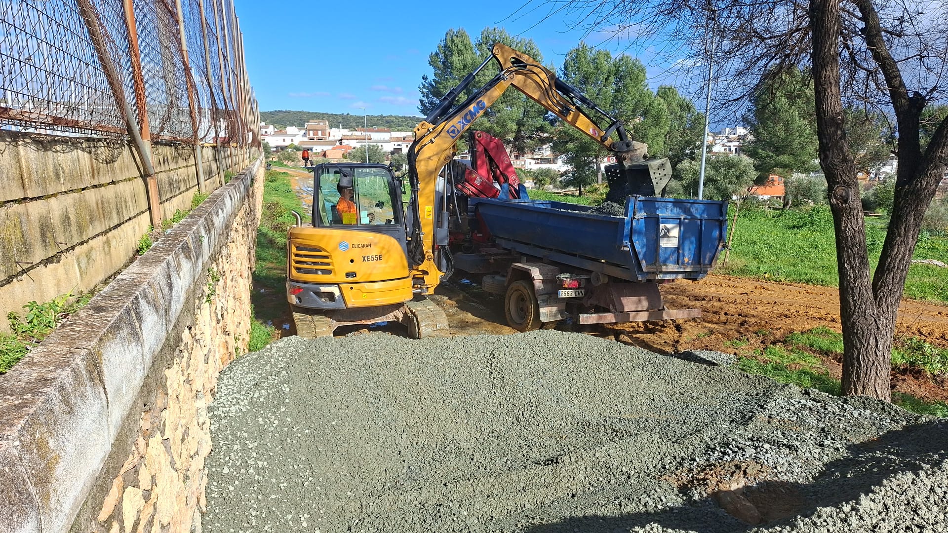 Mini excavadora cargando camión en obra