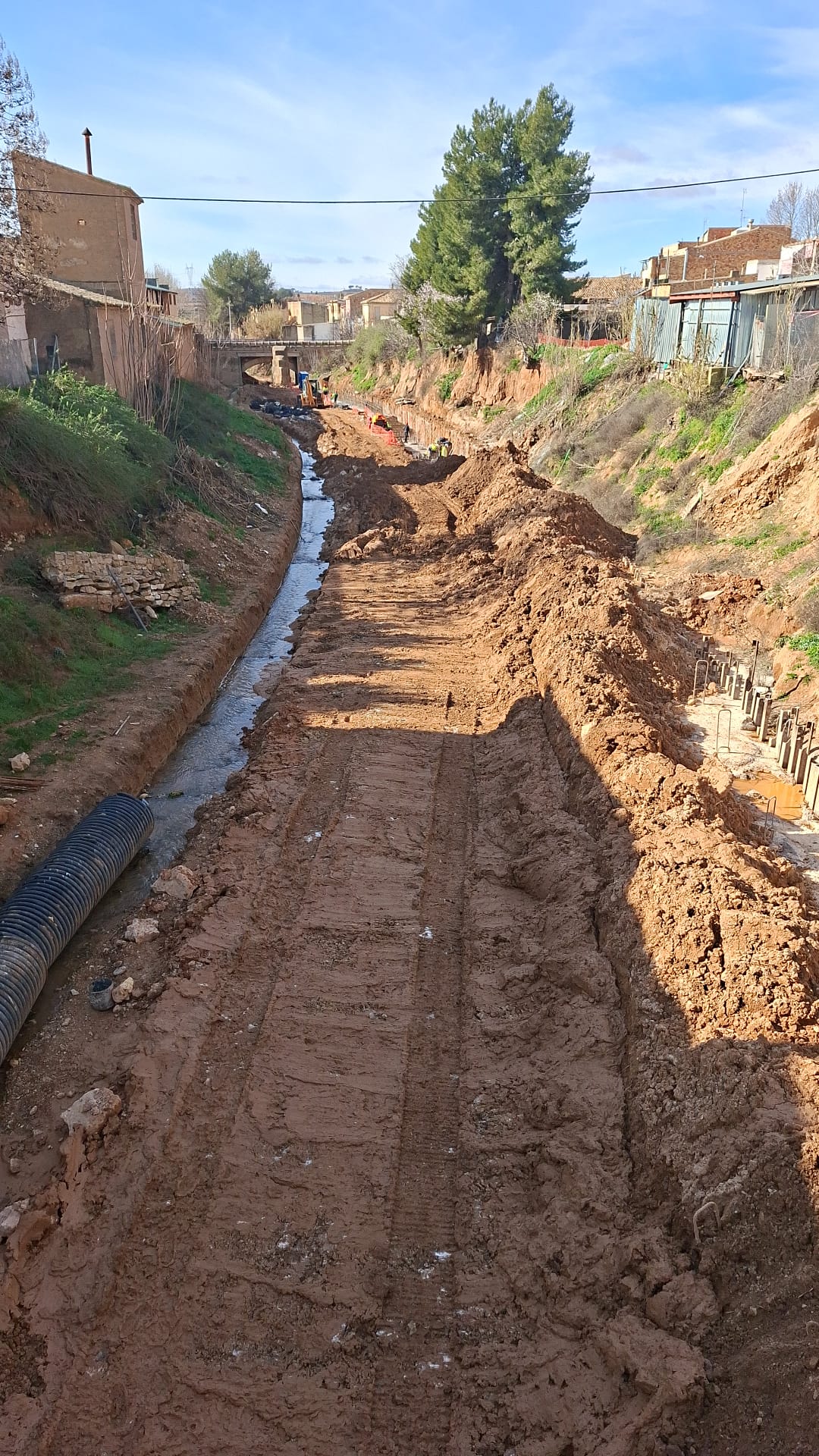 Mini excavadora realizando canalización en finca