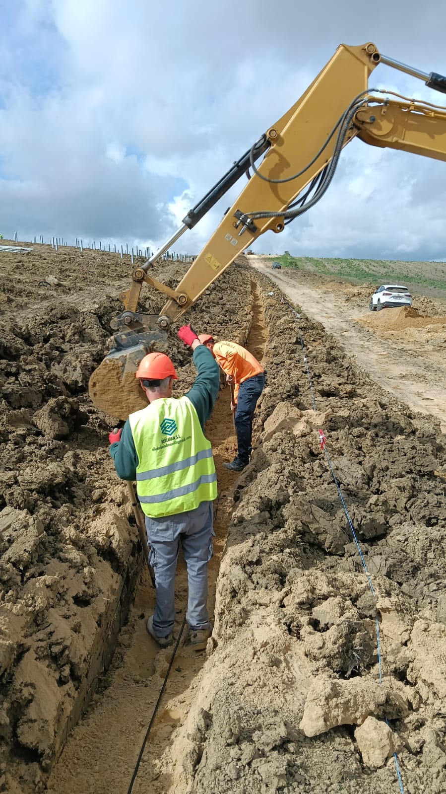 Operarios trabajando en una zanja con apoyo de excavadora